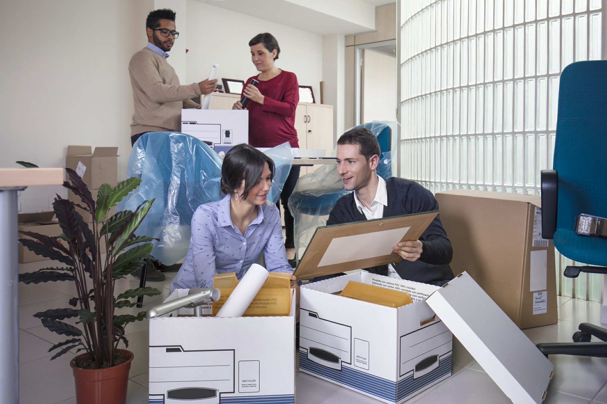Office workers unpacking boxes and setting up a new workspace during a commercial relocation with Chess Moving.