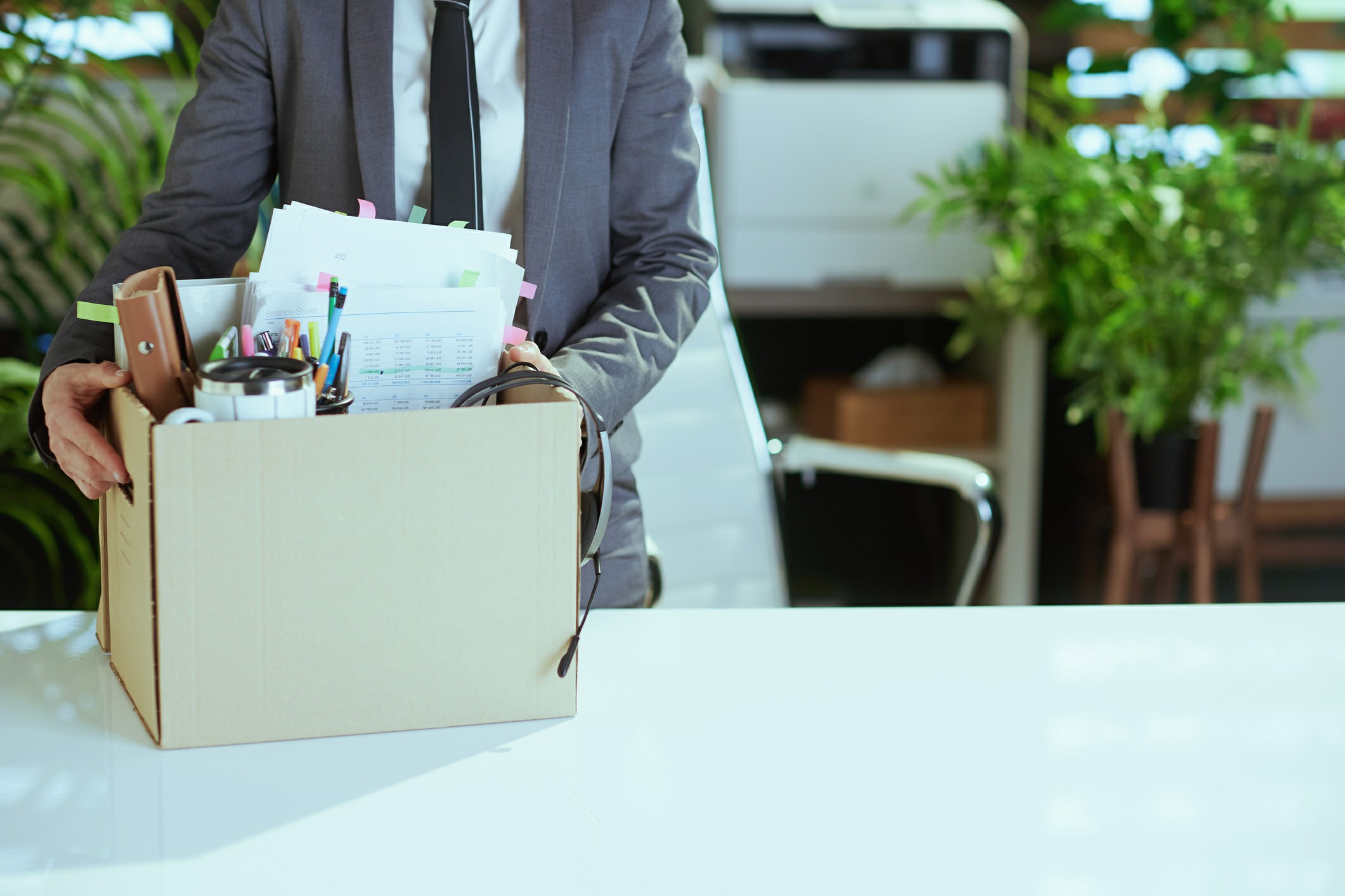Business professional packing office supplies into a cardboard box during corporate relocation with Chess Moving.