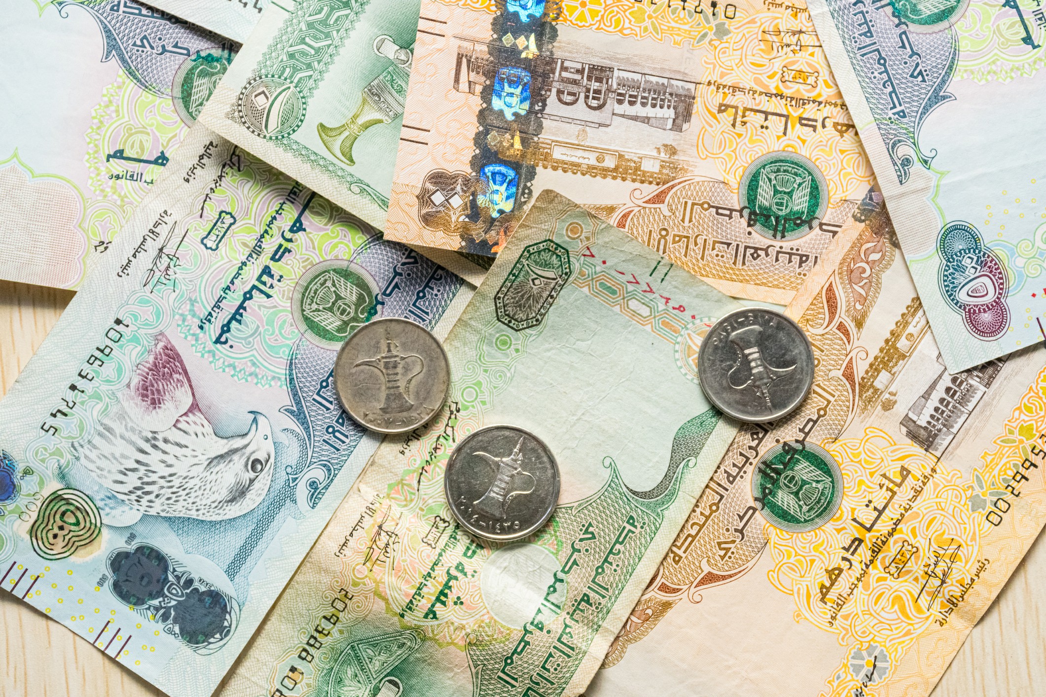 pile of money featuring various coins and banknotes stacked together, symbolizing wealth and currency. Cost of Living in Dubai What to Expect After Your Move