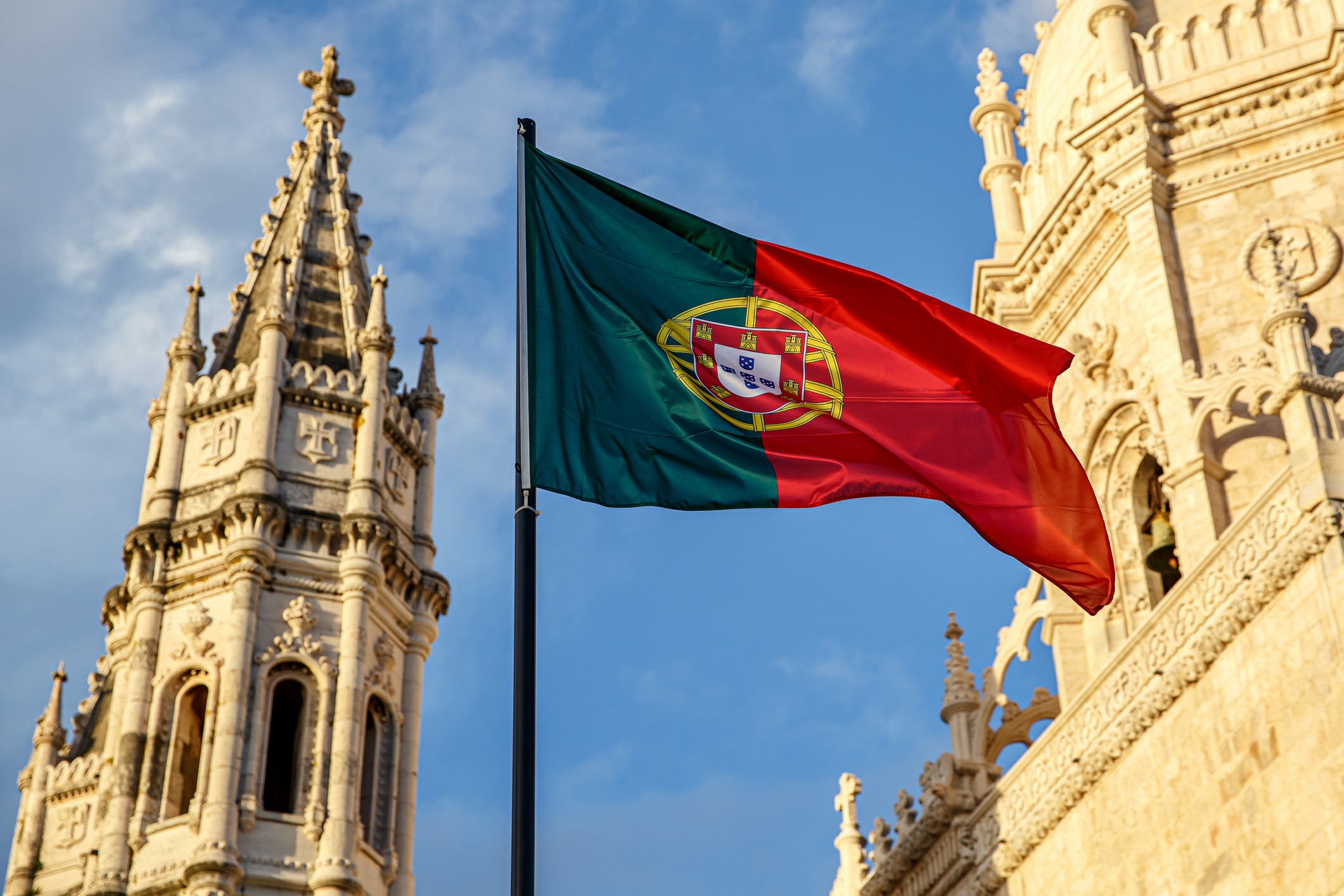 Moving Overseas from Perth to Portugal with Chess Moving Overseas Removalists An impressive building alongside the Portugal flag waving in the breeze.