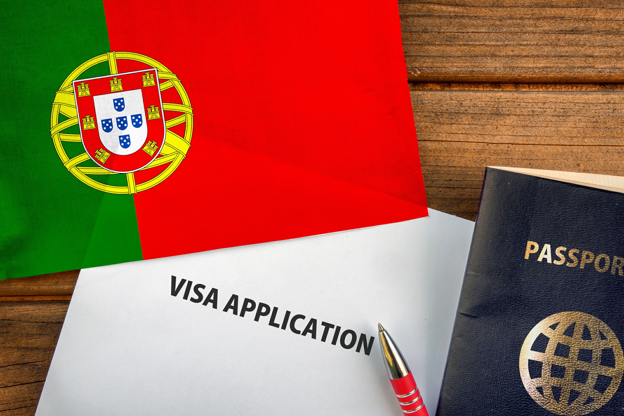 Understanding Visa and Legal Requirements for Portugal Image of a Portugal visa application form with a pen and passport, symbolizing the process of obtaining a visa.