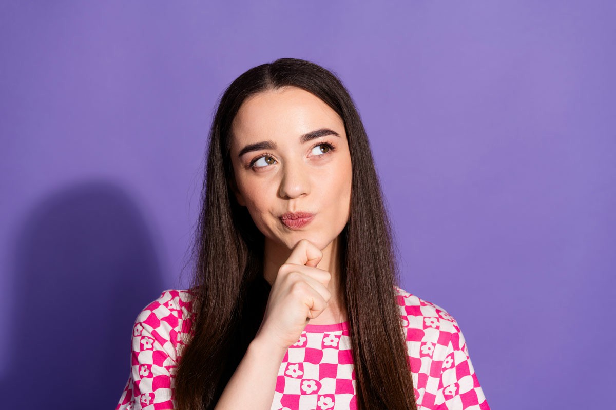 Common Myths About Culture Shock Separating Fact from Fiction A woman with long hair wearing a pink shirt, standing confidently with a serene expression on her face; Common Myths About Culture Shock Separating Fact from Fiction