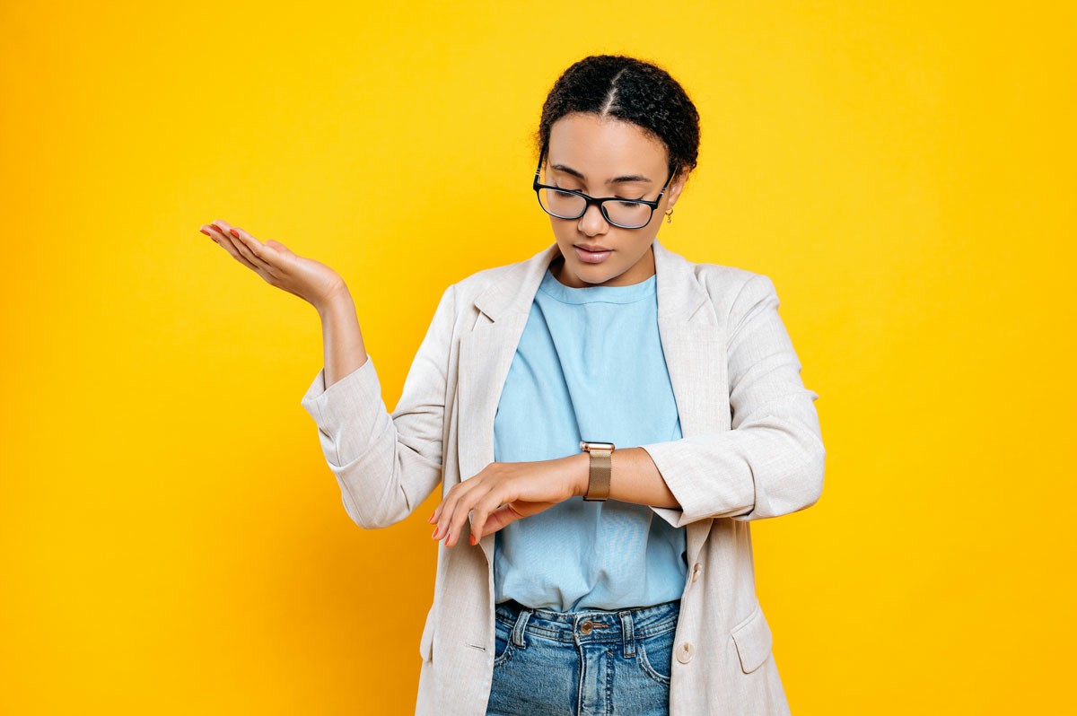Frequently Asked Questions About International Relocations A woman wearing glasses and a blazer holds her wrist, looking thoughtfully to the side. Frequently Asked Questions About International Relocations