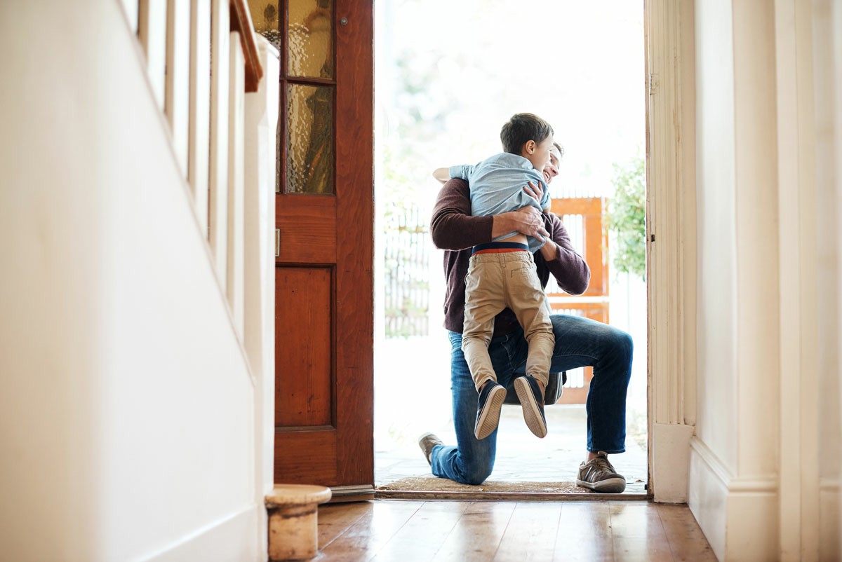 A man and a child sit on the floor, facing a closed door in a cozy indoor setting. How to Repatriate With Ease After Living Abroad