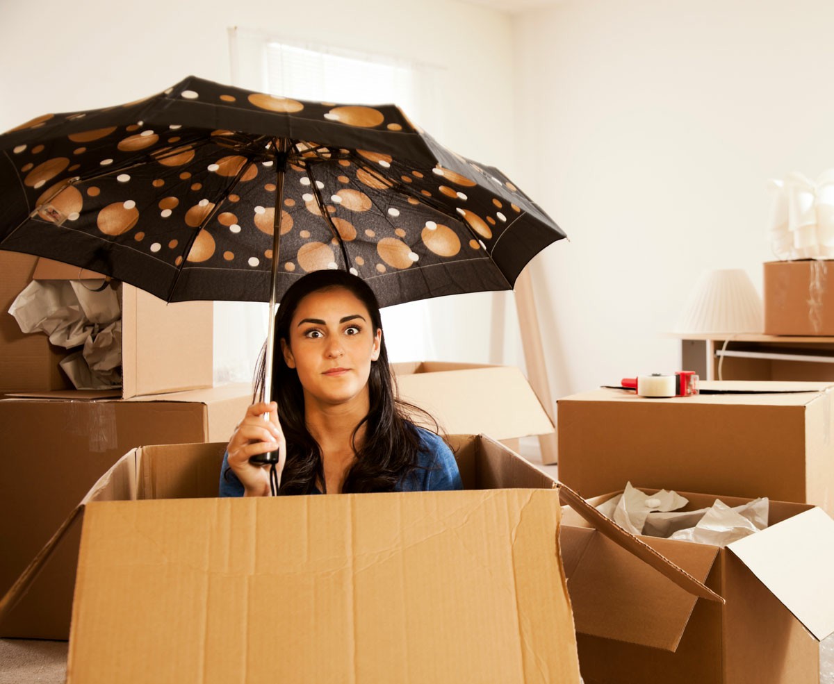 Interstate Furniture Removalists vs DIY Moving Which Is The Better Option A woman inside a box with an umbrella, representing the contrast between professional movers and DIY moving options; Interstate Furniture Removalists vs DIY Moving Which Is The Better Option