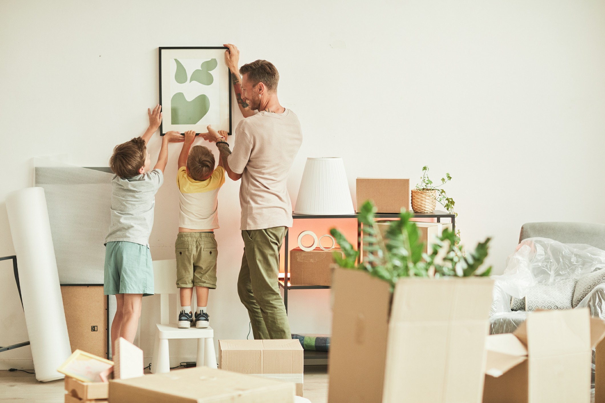 Father and kids putting up image in new overseas home