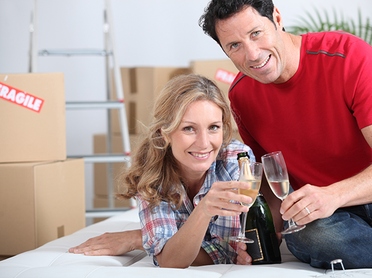 Couple toasting white wine, packing fragile items