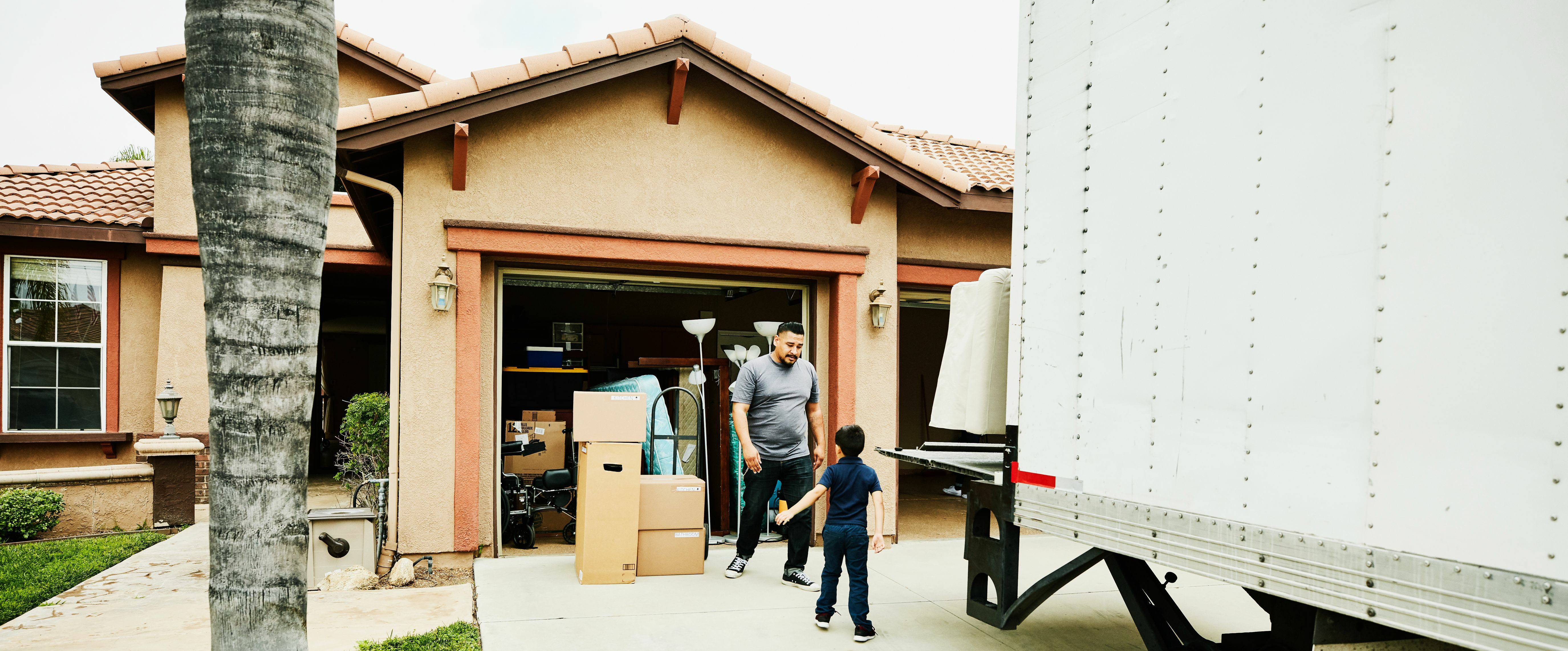 father and son loading things into the moving truck, ready for house relocation