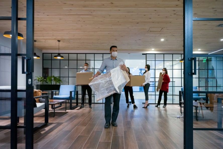 employees wearing facemask while unpacking things, office moving insurance